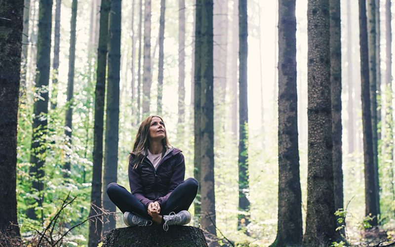 Frau meditiert im Wald