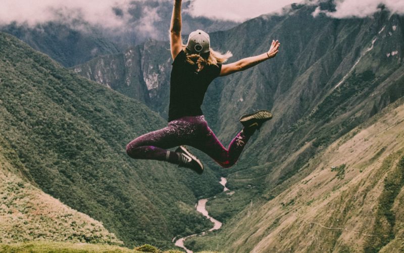 Frau springt in den bergen vor Lebensfreude